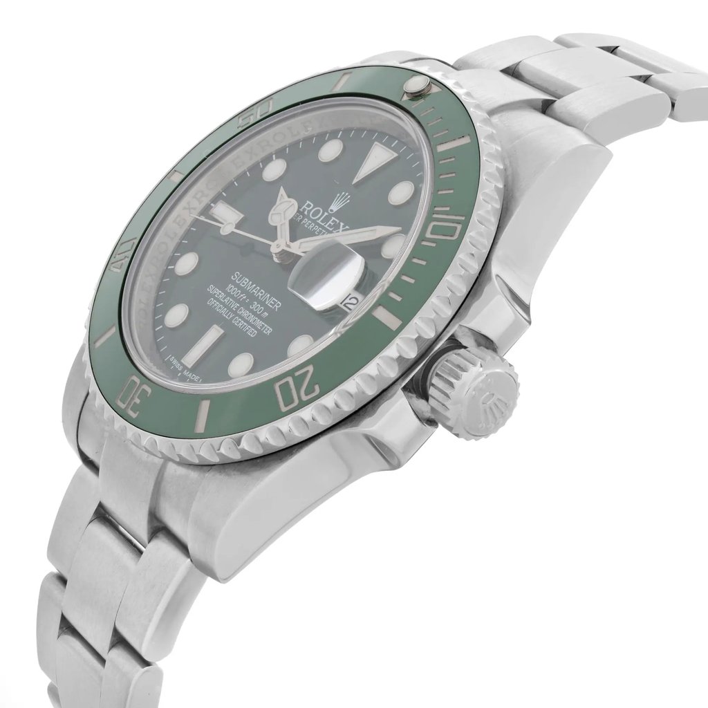 An image of a pre-owned wristwatch taken from a side profile view, highlighting the crown prominently. The watch has a metallic bracelet and a green bezel. The angle captures the thickness of the case and the detailed design of the crown, with the watch face partially visible. The photograph is taken from a relatively close distance, showcasing the watch's features clearly.