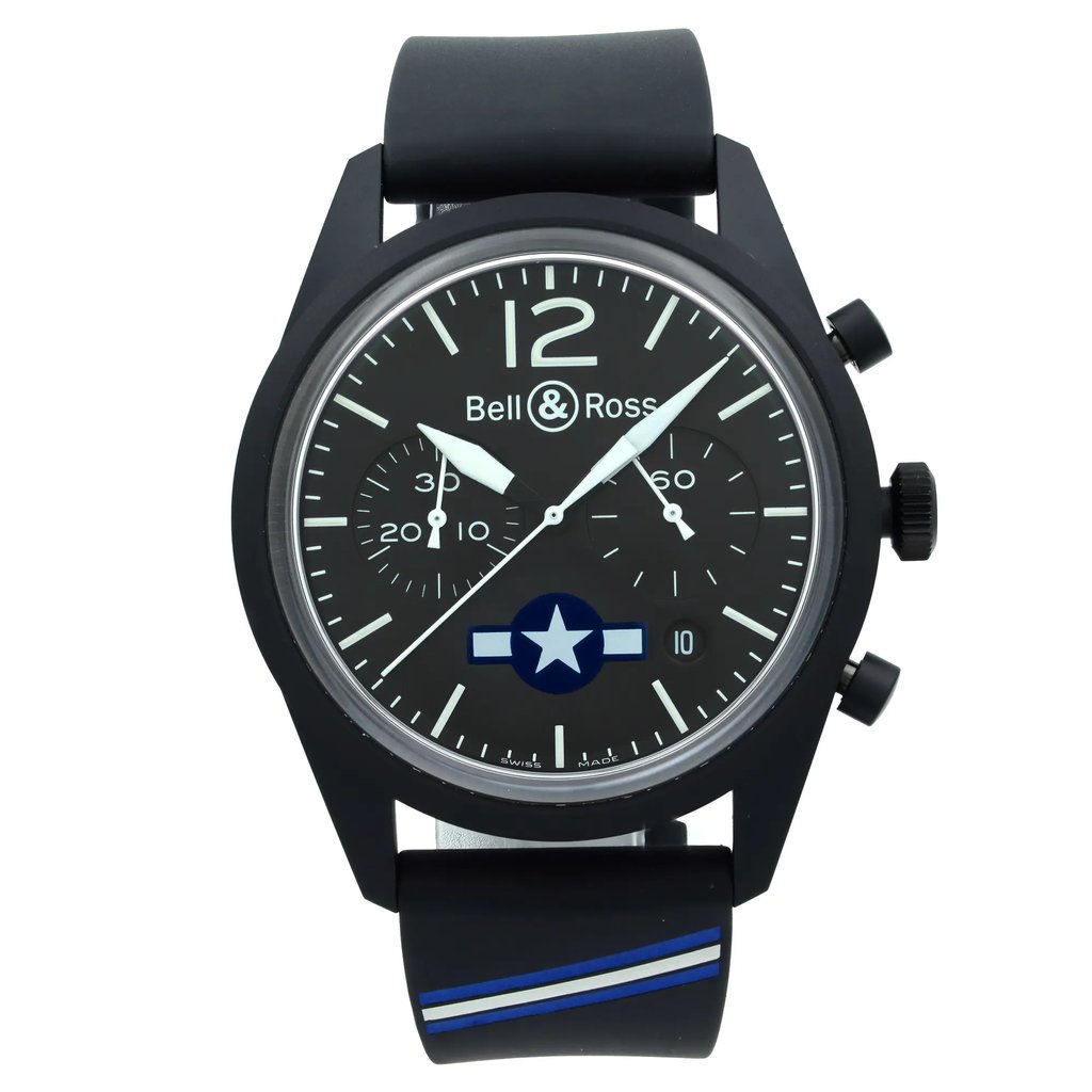 An image of a wristwatch shown in a frontal view, positioned centrally and close-up with the entire watch being displayed. The watch has a black case and strap, with a black dial featuring white stick indices and the logo "Bell & Ross" at the top right below the 12 hour marker. It has a star insignia above the 6 o'clock position. The strap has a blue stripe detail near the case. Watch condition is unworn