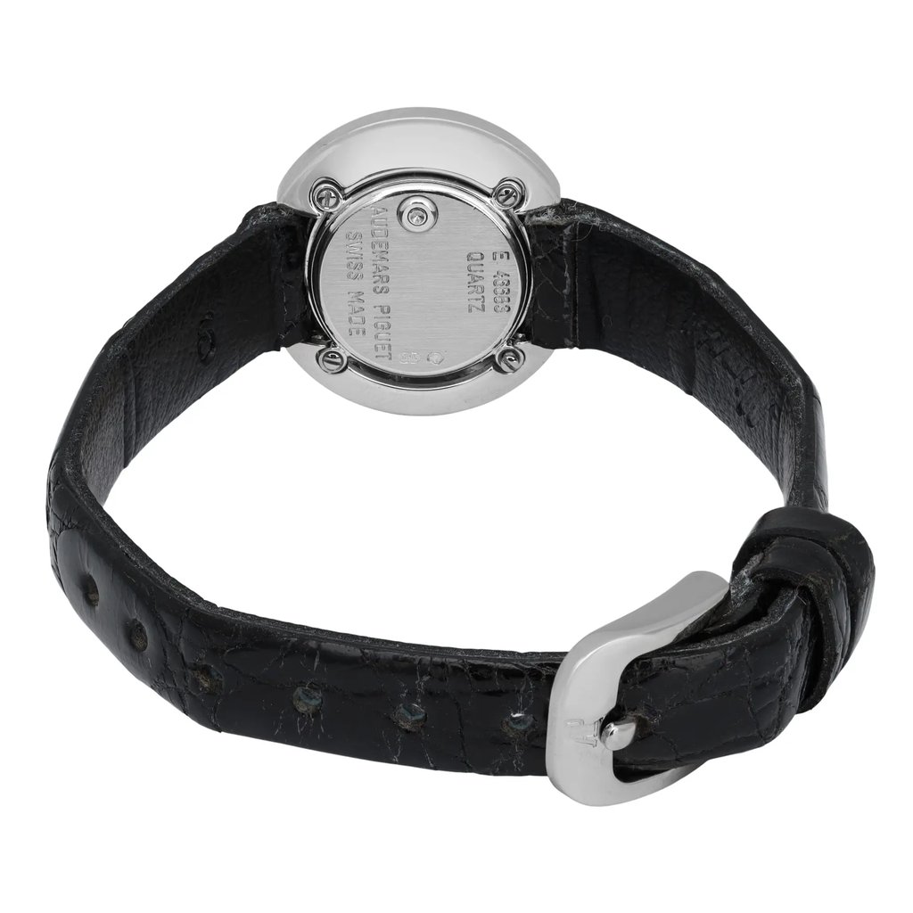 An image of a pre-owned Audemars Piguet women's wristwatch. The watch is positioned with its back facing the viewer, displaying the engraved details on the case back. The angle is slightly from above, showing the full length of the black leather strap with a silver buckle. The watch is photographed at a close distance, highlighting its craftsmanship and condition.