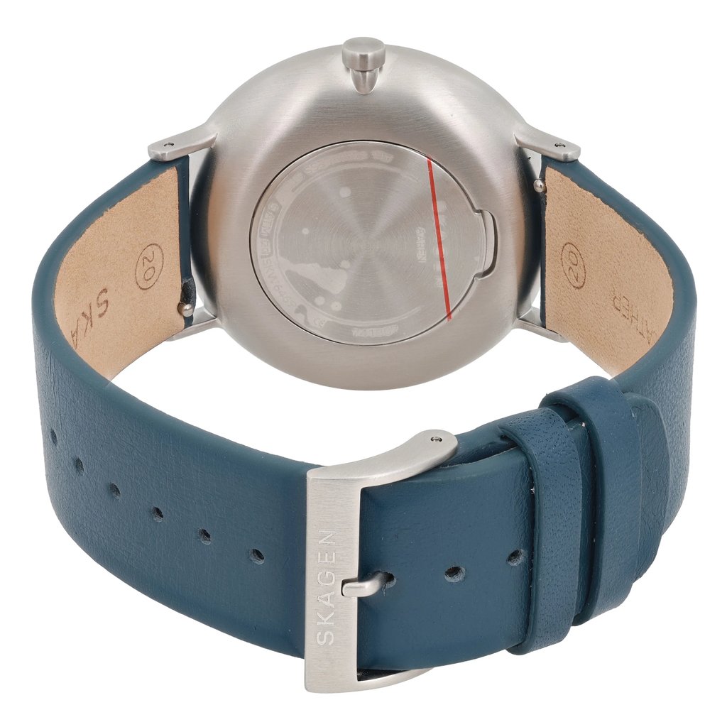 An image of a Skagen men's wristwatch taken from a rear angle, showcasing the back of the watch case and the blue leather strap. The watch features a brushed stainless steel finish with a small seconds subdial on the front, though not visible in this view. The strap is laid out with its buckle facing the viewer, displaying the Skagen branding. The image is taken at a close distance, highlighting the details and texture of the materials.
