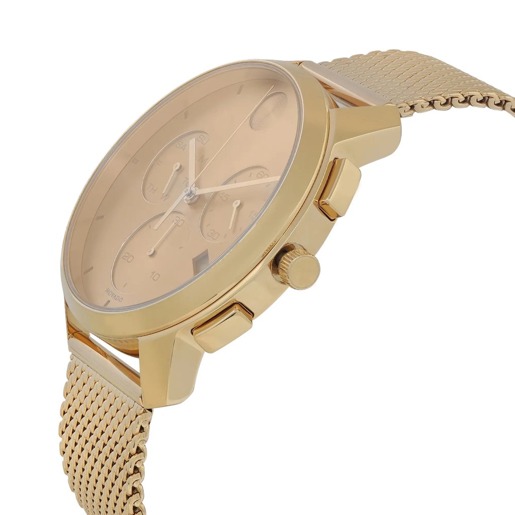 An image of a wristwatch captured from a side profile view, highlighting the crown. The watch has a gold-toned metal case and a matching mesh band. The angle emphasizes the sleek design and detailing of the watch face, including the sub-dials. The watch is positioned close-up, showcasing its new condition with slight defects.