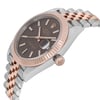An image of a pre-owned men's Rolex Datejust 41mm wristwatch, positioned at a slight angle from the right side, showcasing its elegant two-tone metal band in steel and rose gold. The watch features a chocolate dial with a date indicator and luminous hands, enclosed in a rose gold fluted bezel. The crown is visible on the right side of the case, and the image is captured from a close distance to highlight the watch's details.