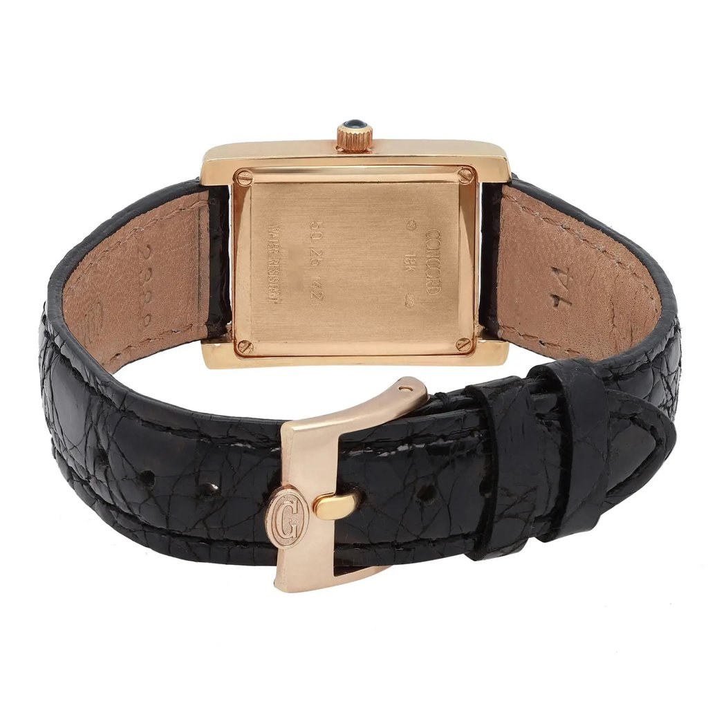 An image of a pre-owned wristwatch, showcasing the back view with a close-up of the clasp. The watch features a rectangular gold case with visible engravings and a black leather strap. The angle highlights the texture of the strap and the detailing on the clasp, positioned centrally in the frame.