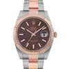 An image of a pre-owned Rolex men's wristwatch with a front close-up view of the round watch face. The dial is chocolate in color, featuring rose gold stick indices, luminous hands, and a date indicator at the 3 o'clock position. The bezel is rose gold, while the band is made of a combination of rose gold and stainless steel. The watch exhibits excellent condition with minor signs of wear and is at a close distance with the face positioned directly towards the camera. The watch shows minor signs of wear or scratches.