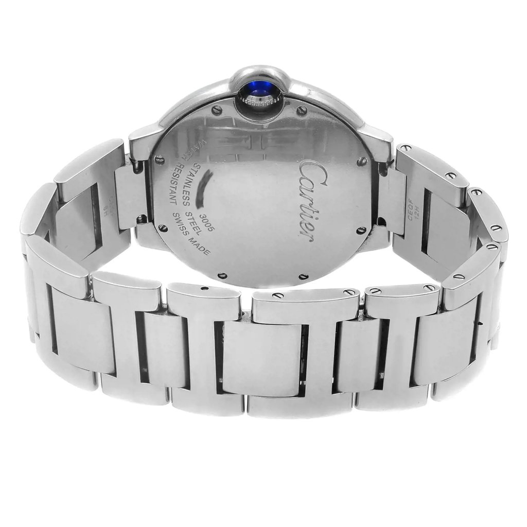 An image of a pre-owned Cartier unisex wristwatch viewed from the back, displaying the screwback case and hidden fold clasp of the stainless steel band. The watch is positioned centrally and angled slightly to show the curvature of the round case and the clasp mechanism. The band extends towards the foreground, indicating a close-up perspective. The sapphire cabochon crown is visible at the top edge of the case.