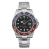 An image of a pre-owned Rolex men's wristwatch in excellent condition, viewed frontally at a close, straight-on angle. The luxury timepiece features a round black dial with luminous hands, round indexes, and a date indicator at the 3 o'clock position. It has a blue and red-colored bezel and is made of white gold, including the band. The watch has a round shape with a 12-hour dial and a second hand.
