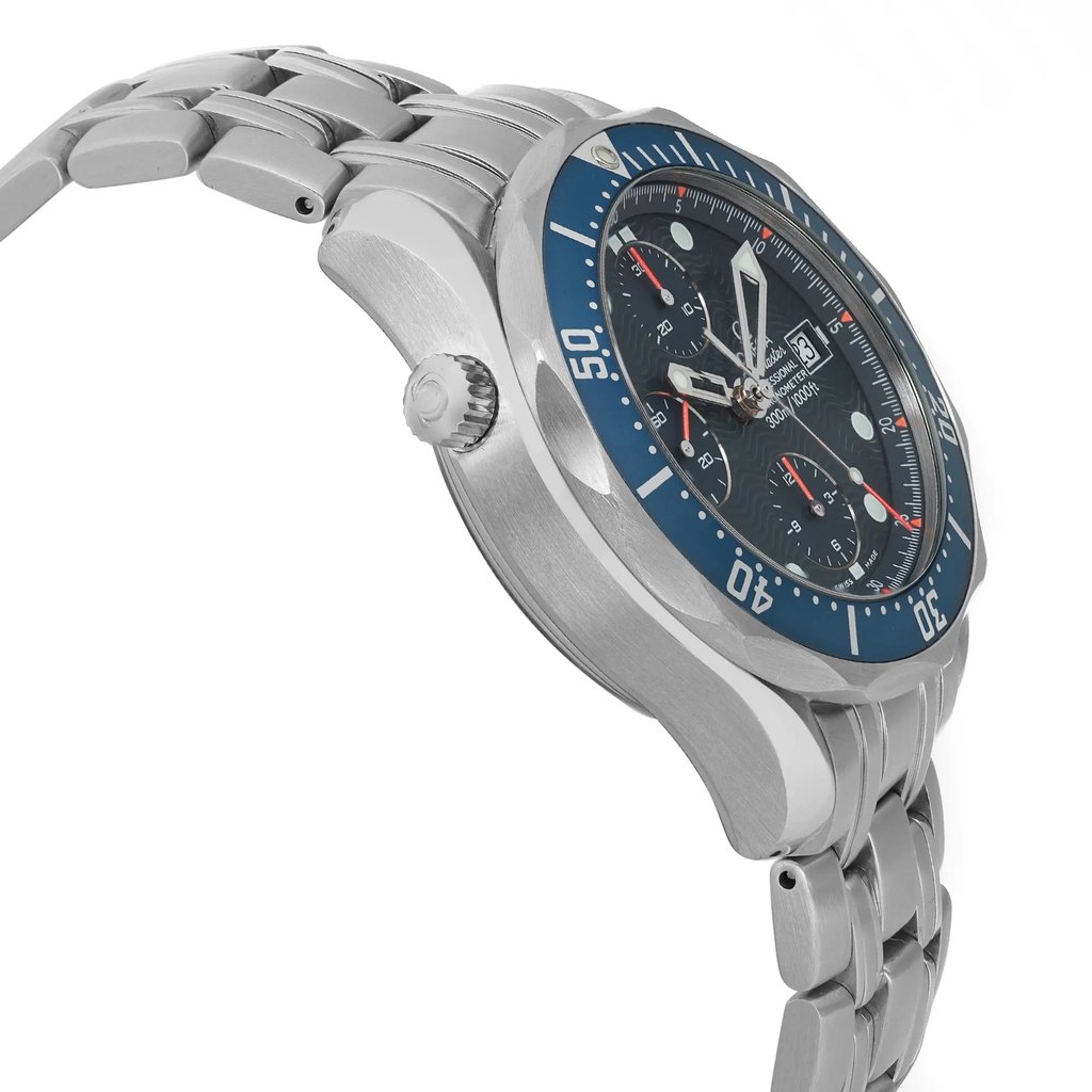An image of a pre-owned OMEGA men's wristwatch in a side profile view from the angle opposite the crown, showcasing its stainless steel case and bracelet. The watch is positioned at a close distance, with a focus on the left side of the watch to highlight the helium escape valve. It features a round shape with a blue and gray bezel, and a blue ocean wave pattern dial. There are minor scratches and nicks on the bezel insert. The watch shows light signs of wear or scratches. 