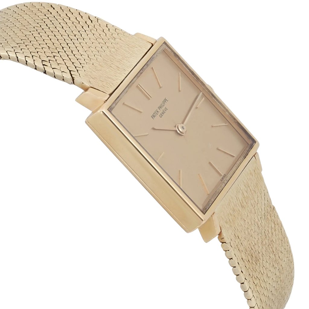 An image of a pre-owned Patek Philippe unisex wristwatch. The watch is positioned at a slight angle, showcasing its rectangular face and yellow gold dial with minimalistic markers. The gold mesh strap is partially visible, extending from the watch's body. The photo is taken from a close distance, highlighting the watch's elegant design and craftsmanship.
