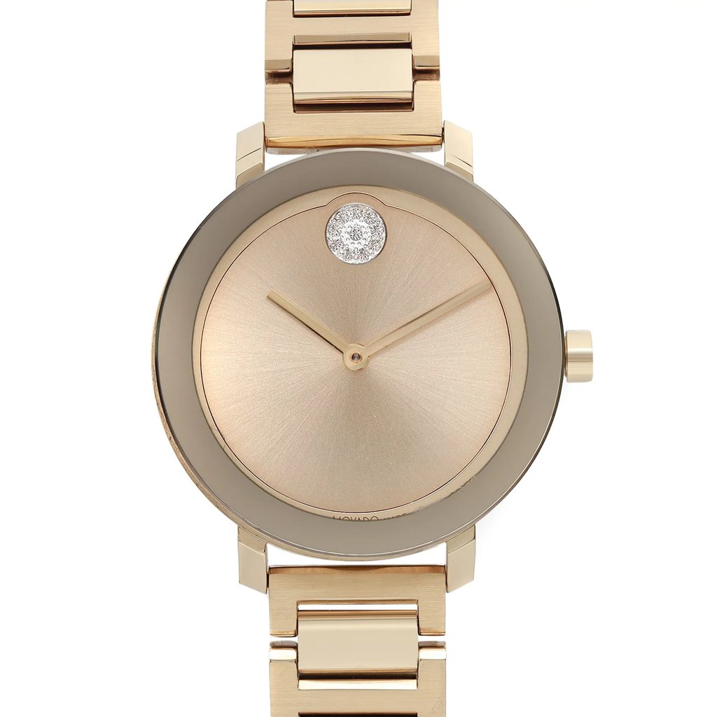 An image of a pre-owned wristwatch shown from a front close-up angle, focusing on the watch face. The watch has a gold-toned dial with minimalistic design elements, featuring a single diamond accent at the 12 o'clock position. The watch is set against a matching gold-colored bracelet.