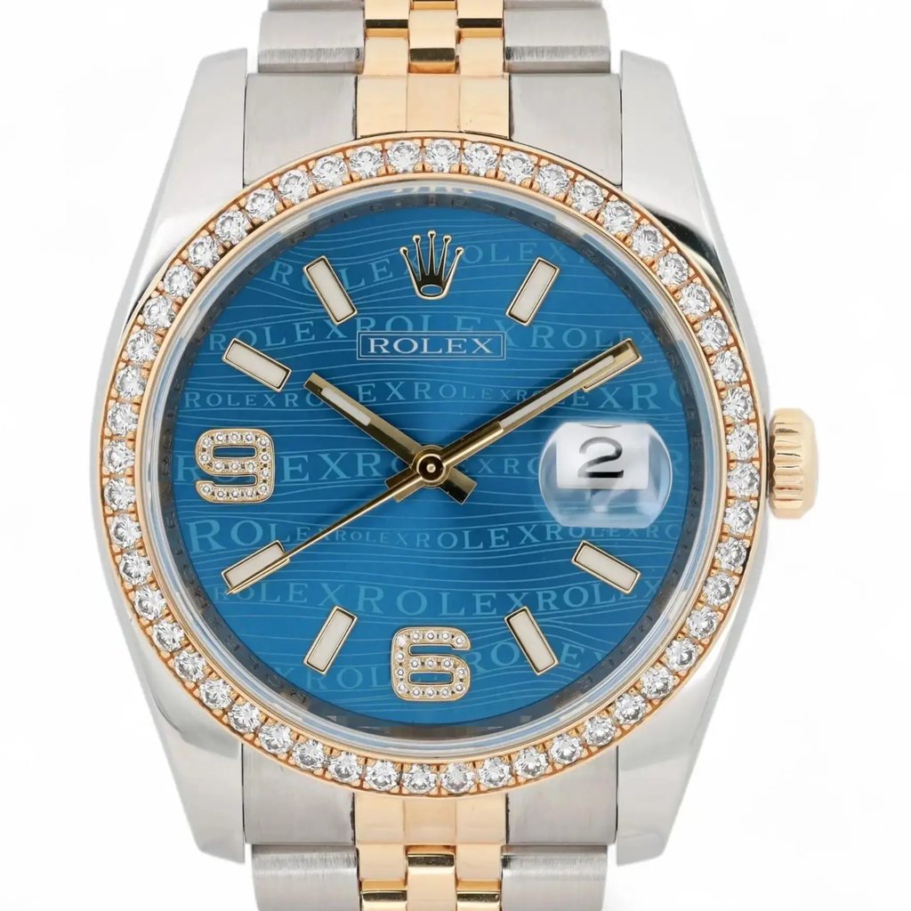An image of a pre-owned unisex Rolex wristwatch taken from a front-facing angle. The watch features a blue dial with "Rolex" text pattern, gold hour markers, and a date indicator at the 3 o'clock position. The bezel is adorned with diamonds, and the watch case is two-tone, combining ssteel and gold elements. The image is captured at a close distance, highlighting the intricate details of the design.