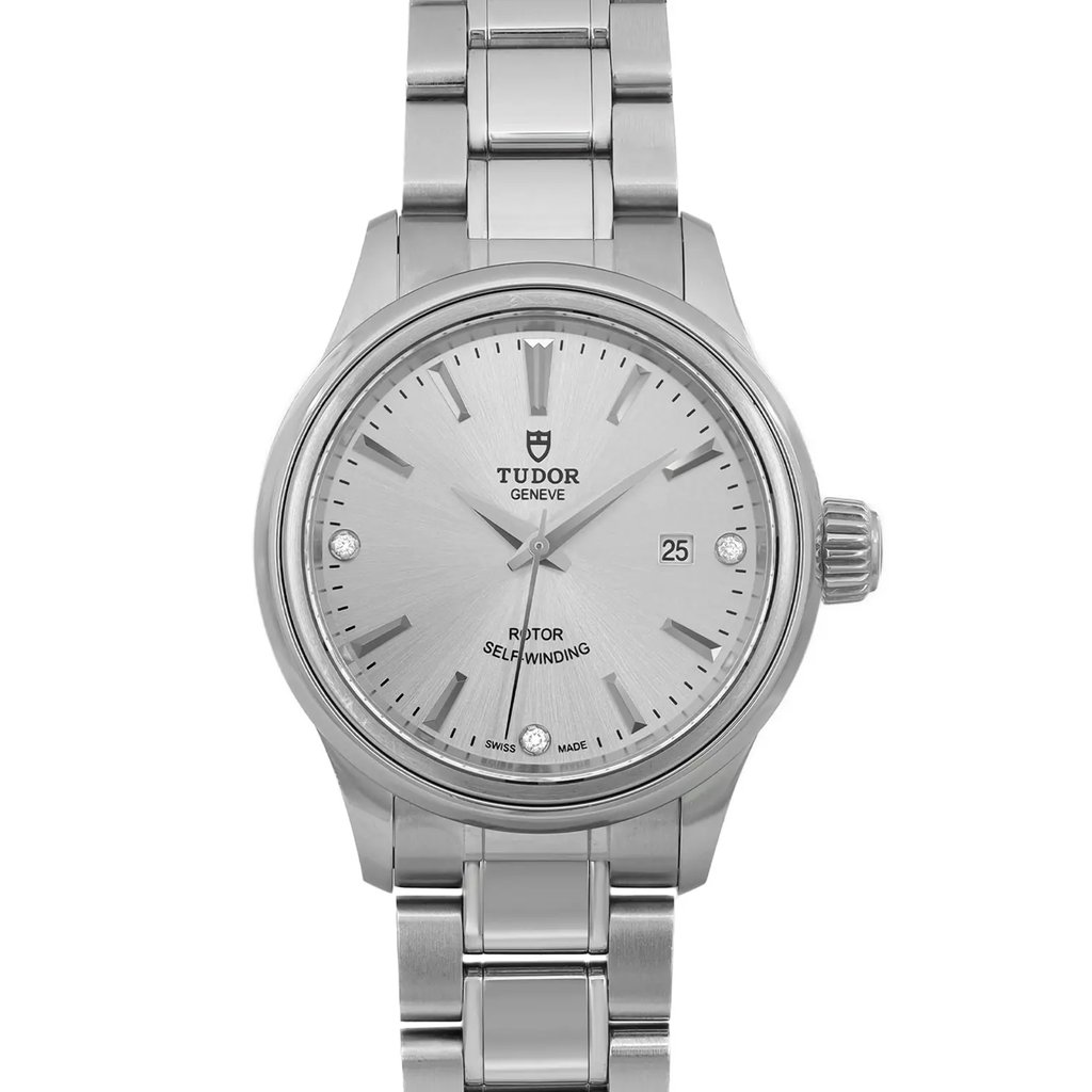 An image of a wristwatch taken from a front close-up angle, showcasing the watch face in pristine, unworn condition. The watch features a silver dial with sleek hour markers and a date display. The stainless steel bracelet and bezel are prominently visible, highlighting the watch's elegant design.