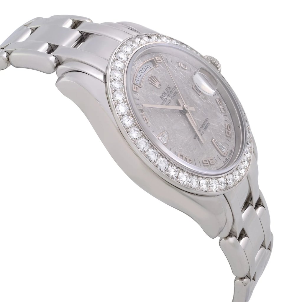 An image of a pre-owned wristwatch captured from a side profile view opposite the crown. The watch features a polished metal bracelet and a round face adorned with a diamond-set bezel. The angle highlights the watch's sleek design and craftsmanship, with the face and bracelet subtly curving in the image. The image is taken from a close distance, emphasizing the details and texture of the materials.