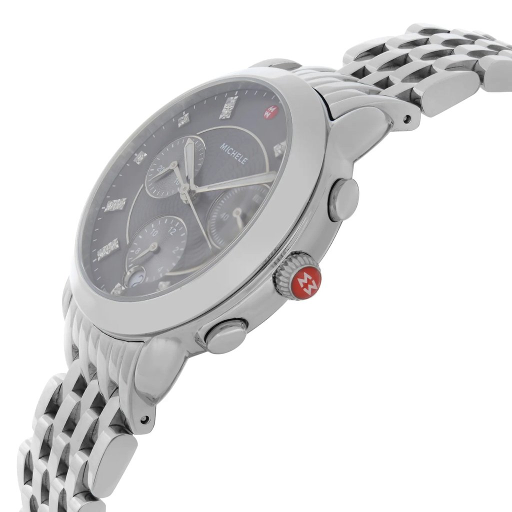 An image of a pre-owned wristwatch captured from a side profile view, showcasing the crown prominently. The watch features a metallic bracelet and a round face with subdials visible. The crown, positioned on the right side, includes a red accent. The angle highlights the watch's sleek design and detailing, taken from a close distance to emphasize its features.