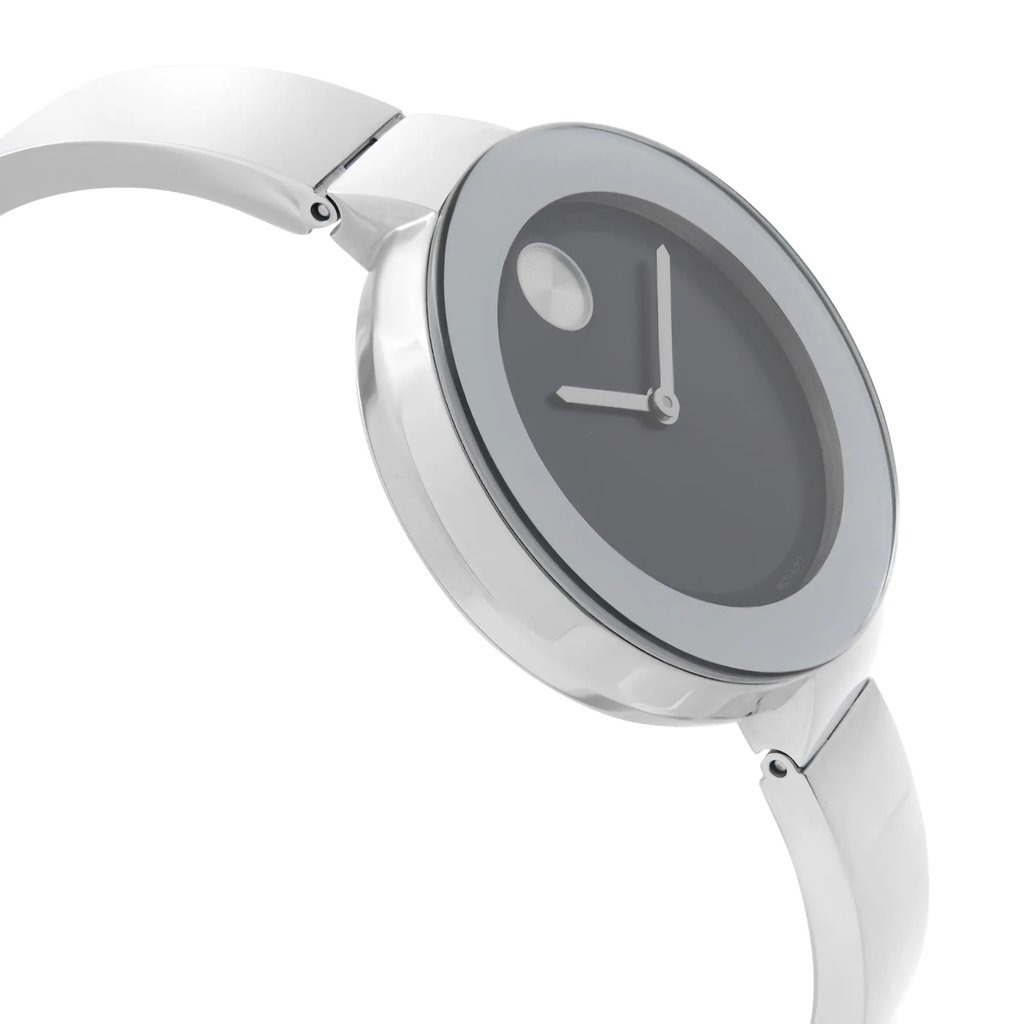 An image of a wristwatch shown from a side profile view, opposite the crown. The watch has a sleek, modern design with a metallic band and a minimalist dial. The angle highlights the watch's thin profile and smooth curves, giving a sense of elegance. The distance allows for a clear view of the watch's face and band, emphasizing its display model condition.