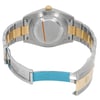 An image of a pre-owned wristwatch taken from the back view, showcasing the open clasp. The watch features a two-tone metal bracelet with silver and gold links. The angle captures the back of the watch case and the inside of the clasp, displaying the intricate details. The photograph is taken from a close distance, allowing for a clear view of the materials and craftsmanship.