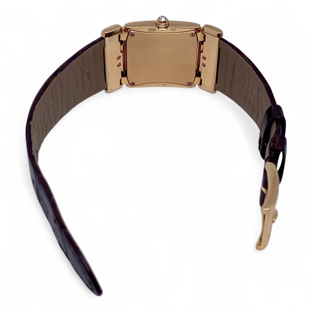 An image of a pre-owned Patek Philippe women's wristwatch. The watch is positioned with the back facing the viewer, displaying its rose gold case and detailing. The strap is extended, and the watch is photographed from a slightly elevated angle, showing the inner side of the leather strap. The image is taken from a close distance, highlighting the watch's craftsmanship and design.