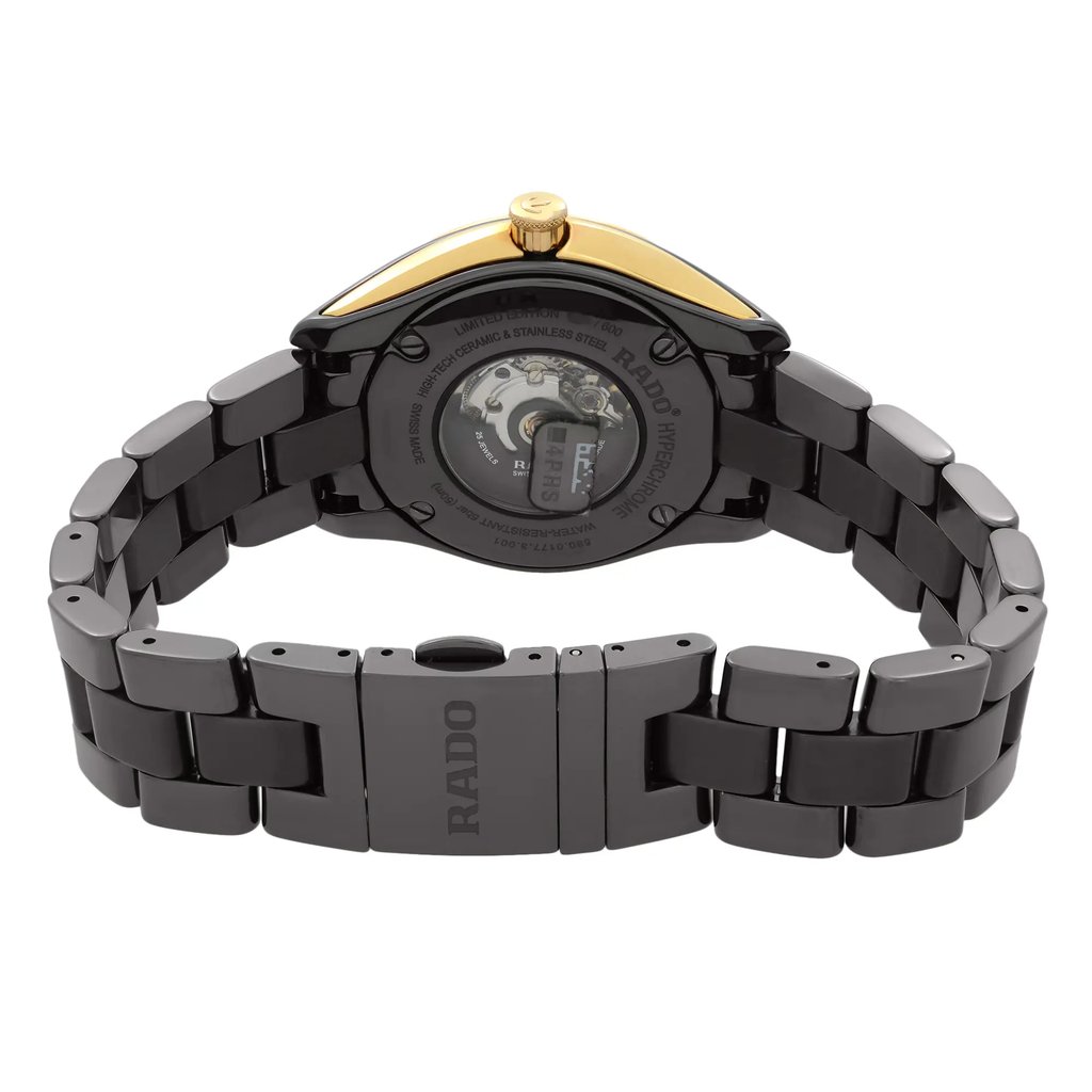 An image of a wristwatch taken from the back view, showcasing the closed clasp. The watch features a glossy black ceramic and stainless steel bracelet with a visible transparent case back, revealing the inner mechanism. The clasp prominently displays the brand name. The image is captured from a close-up angle, highlighting the intricate details and craftsmanship of the display model watch.