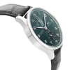 An image of an unworn IWC luxury men's wristwatch, presented in a side profile view opposite the crown, with the focus on the left side of the watch. The watch features a round stainless steel case with a stainless steel bezel and a prominent green dial. The leather band is black, and the watch appears to be in close-up, showcasing the textures and details of the leather and the shine of the steel.