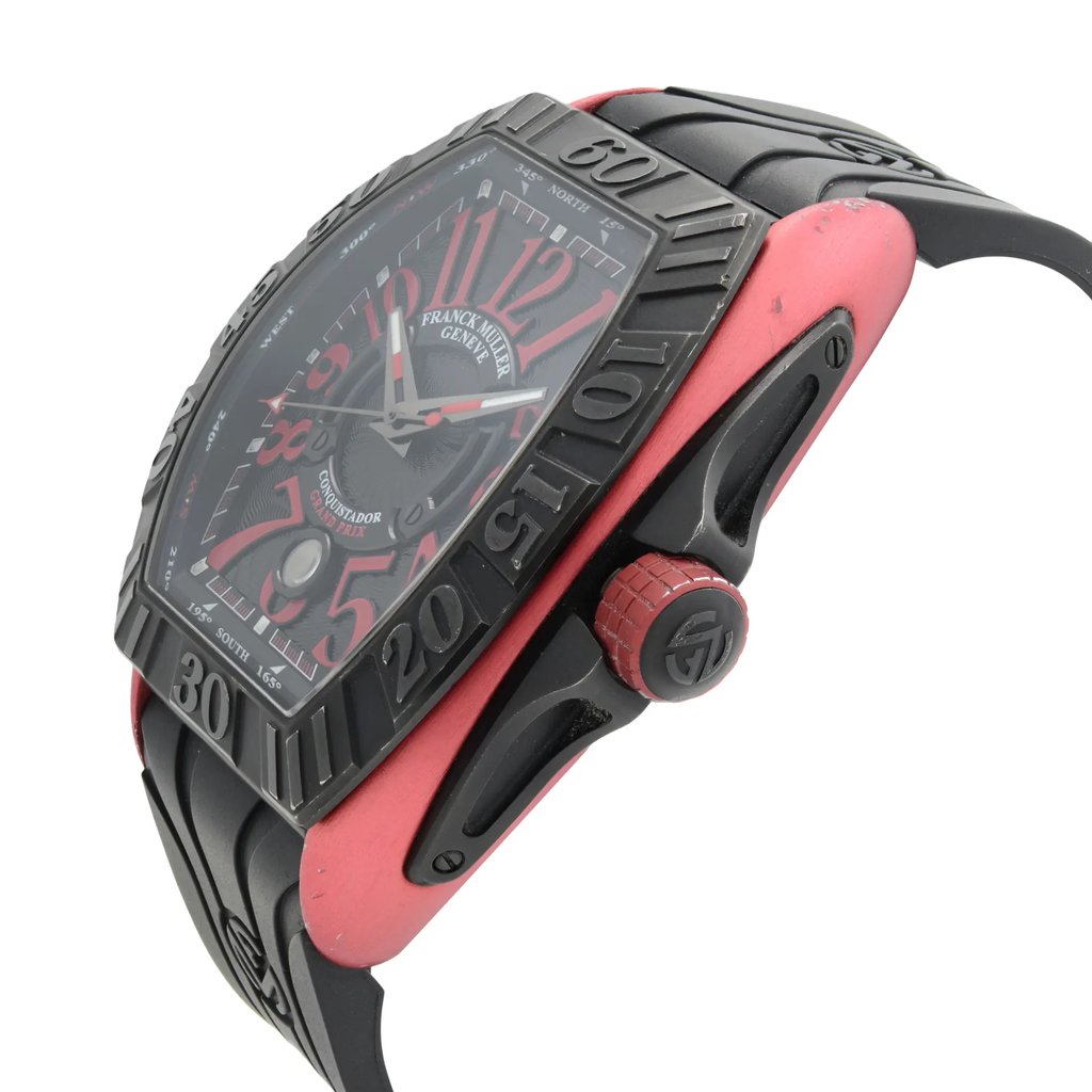 An image of a pre-owned wristwatch shown from a side profile view, highlighting the crown on the right. The watch has a black and red color scheme, with a prominent black bezel and a red crown featuring textured detailing. The angle captures the watch at a slight upward tilt, emphasizing the design and details of the case and strap, suggesting a close-up perspective.