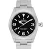 An image of a luxury men's wristwatch in excellent condition, viewed from the front in a close-up shot. The watch has a round black dial with Arabic numerals and luminous hands. The bezel is gray, and both the band and case are made of stainless steel. The watch is a new Rolex without tags.