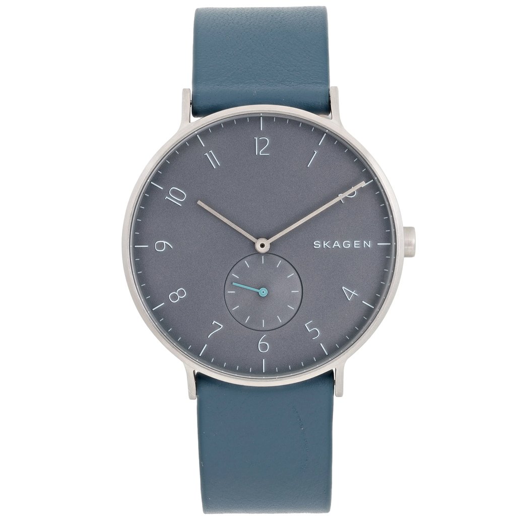 An image of a Skagen men's wristwatch, shown from a front-facing angle at a close distance. The watch features a minimalist design with a dark gray dial and a small seconds subdial. The hour markers are sleek and understated. It has a blue leather strap and a simple silver-toned bezel, accentuating its modern aesthetic.