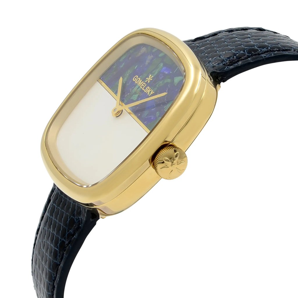 An image of a wristwatch in an unworn condition, viewed from a side profile angle, focusing on the crown. The watch has a rectangular gold-toned case with a decorative crown on the right side. The face features a distinctive design with a mix of colors on the top half and a plain section below. The strap is dark and textured, resembling leather. The image is taken from a close distance to highlight the watch's details.