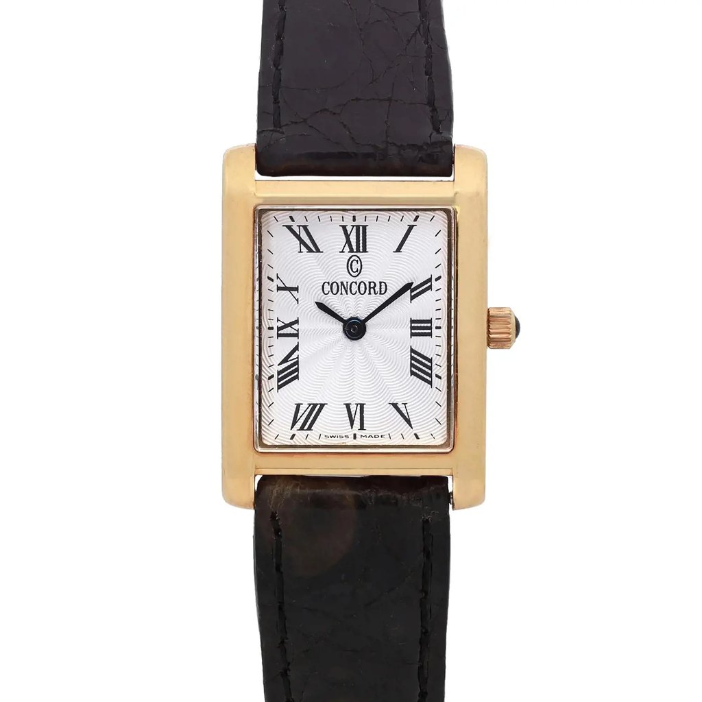 An image of a pre-owned wristwatch featuring a close-up, front view of the watch face. The wristwatch has a rectangular gold-tone case with a white dial displaying black Roman numerals. The brand name is visible on the dial. The watch is positioned vertically, with the crown on the right side, and the leather strap extending upwards and downwards.