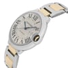 An image of a pre-owned wristwatch viewed from a side profile angle, highlighting the crown. The watch features a round face with Roman numerals and blue hands. The bracelet combines silver and gold tones. The perspective is close-up, emphasizing the watch's elegant design and craftsmanship.