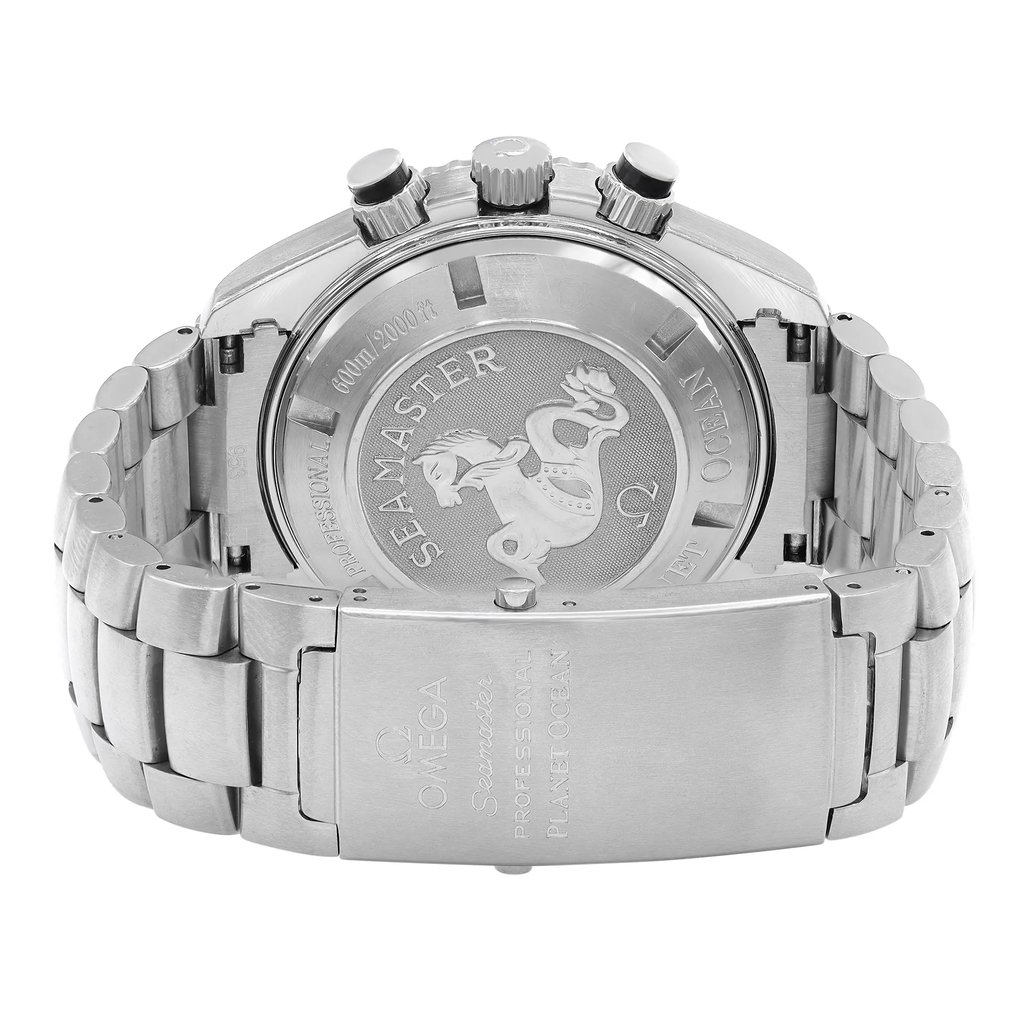 An image of a pre-owned men's OMEGA wristwatch, viewed from the back at a slight angle, showcasing the engraved case back. The watch features a stainless steel bracelet with a visible clasp. The photograph is taken at a medium distance, focusing on the intricate details of the engravings, including the "Seamaster" branding and an embossed emblem. The chronograph pushers and crown are also visible on the side of the case.