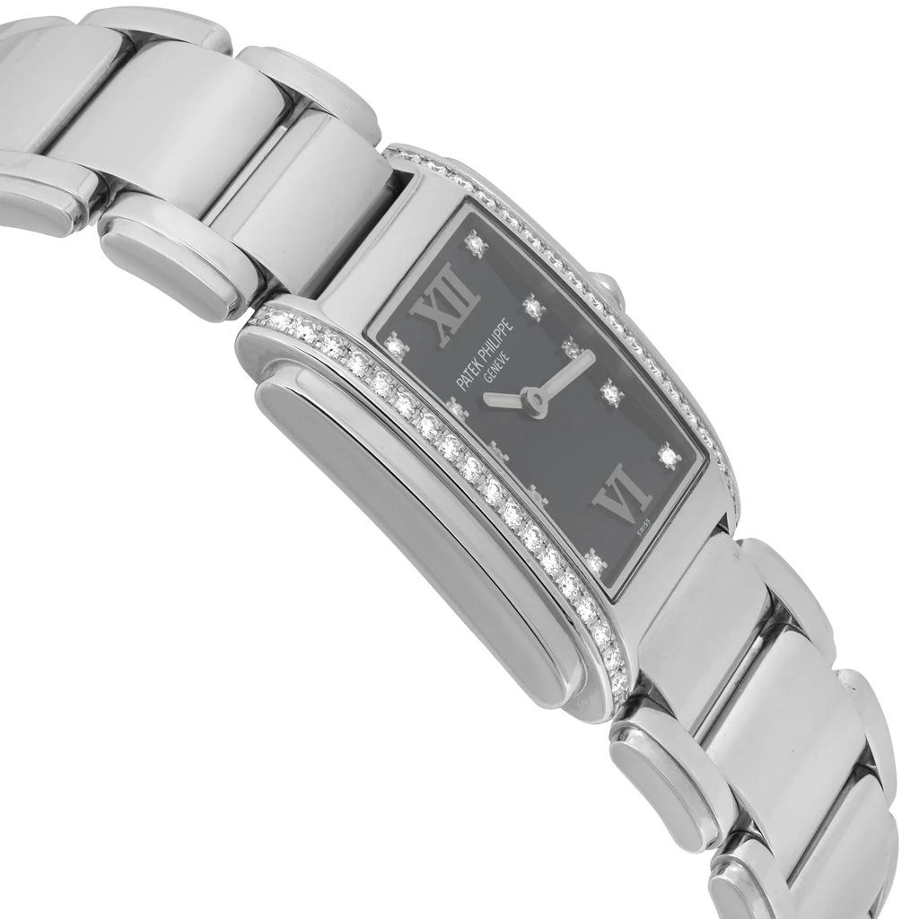 An image of a pre-owned women's Patek Philippe wristwatch positioned at a slight angle, showcasing its elegant design. The watch features a rectangular face with Roman numeral markers and luminous hands. The silver-toned bracelet and bezel are adorned with small diamonds, enhancing its luxurious appearance. The angle highlights the watch's side profile, emphasizing its sleek and sophisticated craftsmanship.