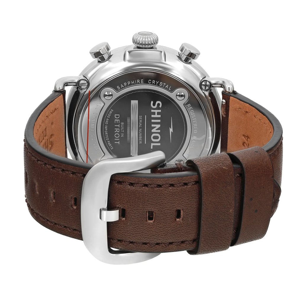 An image of a Wristwatch by Shinola. This New With Defects item is designed for Men, featuring a Casual style. It has a Quartz movement and an Analog display with a Blue dial color. The indices include 12-Hour Dial,Arabic Numerals. The band is made of Leather and the case is made of Stainless Steel. The watch has a Round shape with a case size of 47 mm and a case thickness of 13 mm.