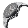 An image of a pre-owned wristwatch shown from a side profile view. The focus is on the crown, which is prominently visible. The watch has a sleek metal case and a black textured bezel. The bracelet is made of polished metal links. The angle highlights the watch's intricate design details, showcasing both functionality and style.