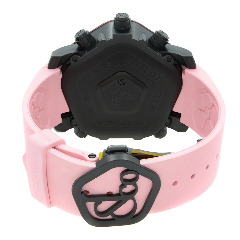 An image of a wristwatch taken from the back view, showcasing the closed clasp. The watch has a pink strap and a black case. The photograph is taken from a slightly elevated angle at a close distance, highlighting the details of the clasp and strap. The watch appears to be a display model.