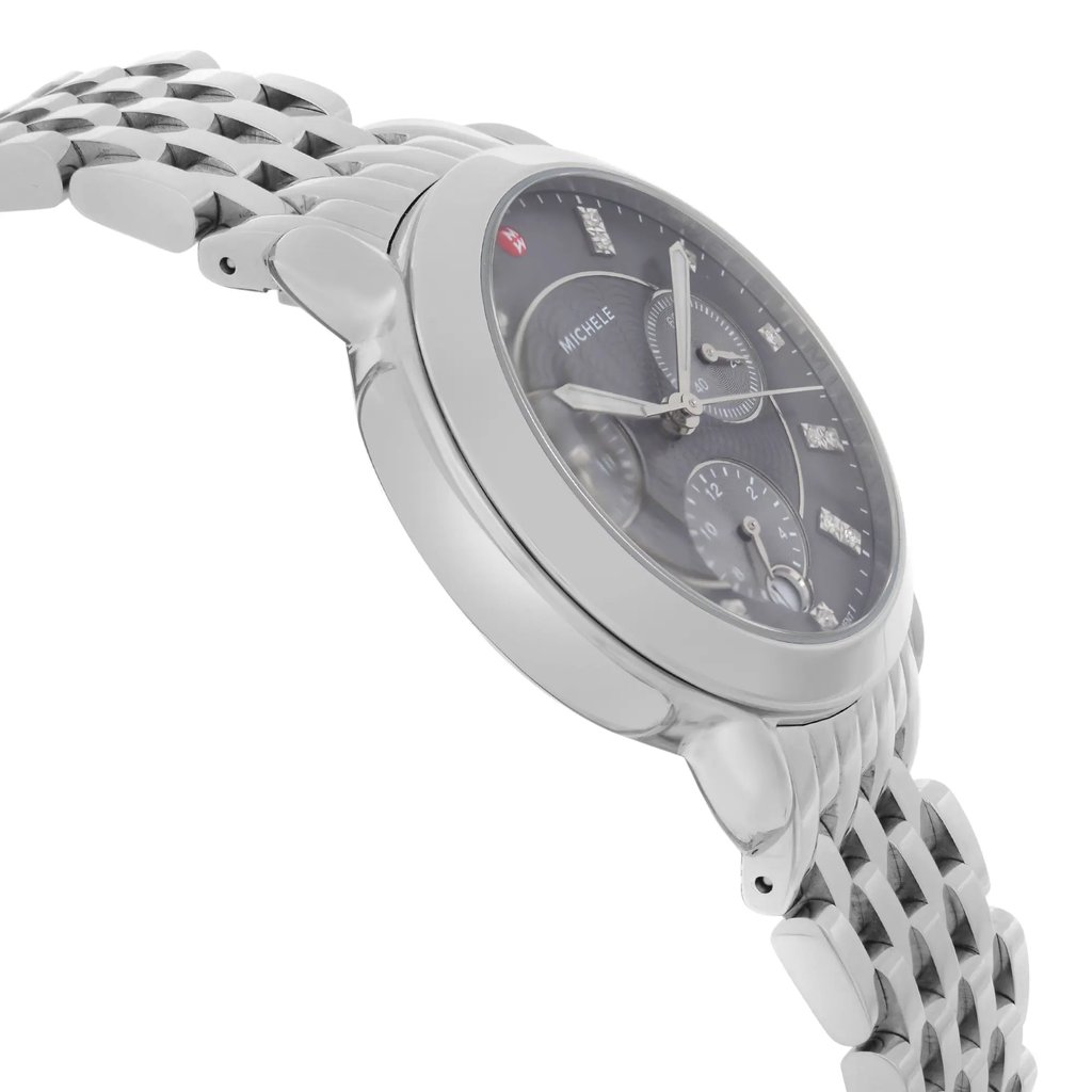 An image of a wristwatch shown from a side profile view, opposite the crown. The angle highlights the watch’s sleek metallic casing and intricate linked bracelet. The watch face displays multiple dials and markers, captured at a slight tilt, providing a detailed view of its design. The photo is taken from a close distance, emphasizing the craftsmanship and condition of this display model.
