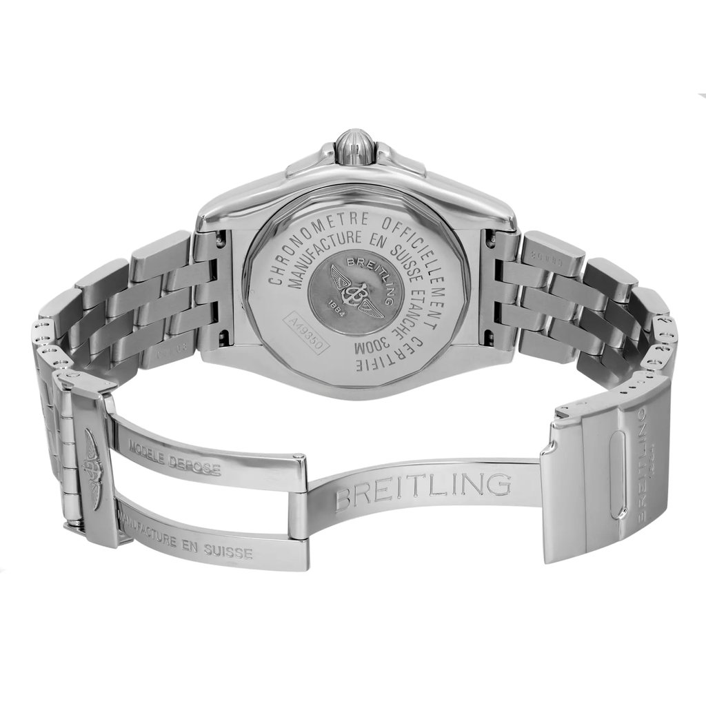 An image of a pre-owned wristwatch taken from the back view, showcasing the open clasp. The angle captures the detailed engravings on the stainless steel back, highlighting the brand name. The watch's metallic bracelet is spread open, displaying the linked design and the engraved clasp. The photograph is taken at a close distance, emphasizing the craftsmanship and condition of the watch.