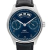 An image of a pre-owned wristwatch taken from a front close-up angle, showcasing the watch face in detail. The watch features a blue dial with an annual calendar display, including the day, date, and month. It has two subdials and silver-tone hands with numerals around the edge. The timepiece is paired with a black leather strap.