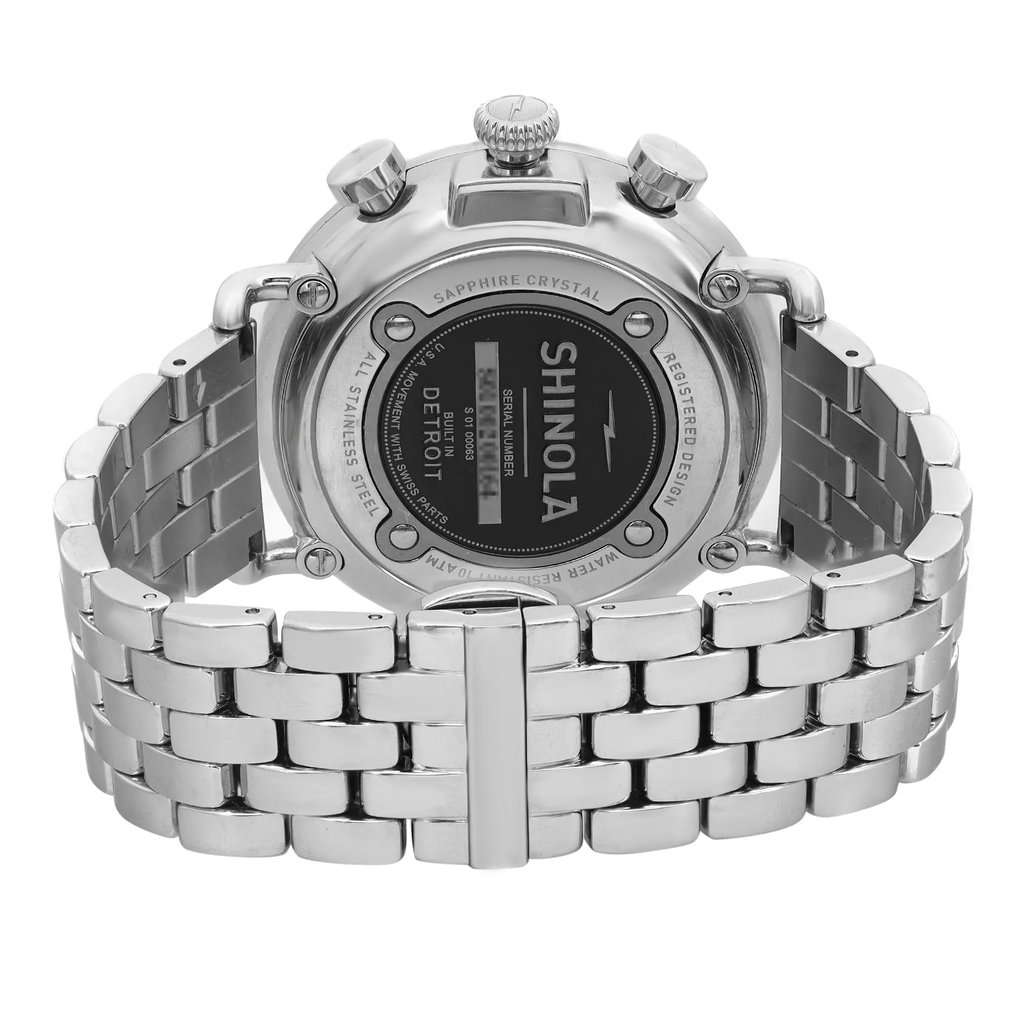 An image of a pre-owned wristwatch shows the back view, focusing on the clasp. The watch features a stainless steel bracelet with a polished finish. The back of the case displays brand details and specifications. The angle is slightly elevated, providing a clear view of the clasp and the intricate links of the bracelet. The image is taken at close range to highlight the details of the watch's construction and design.