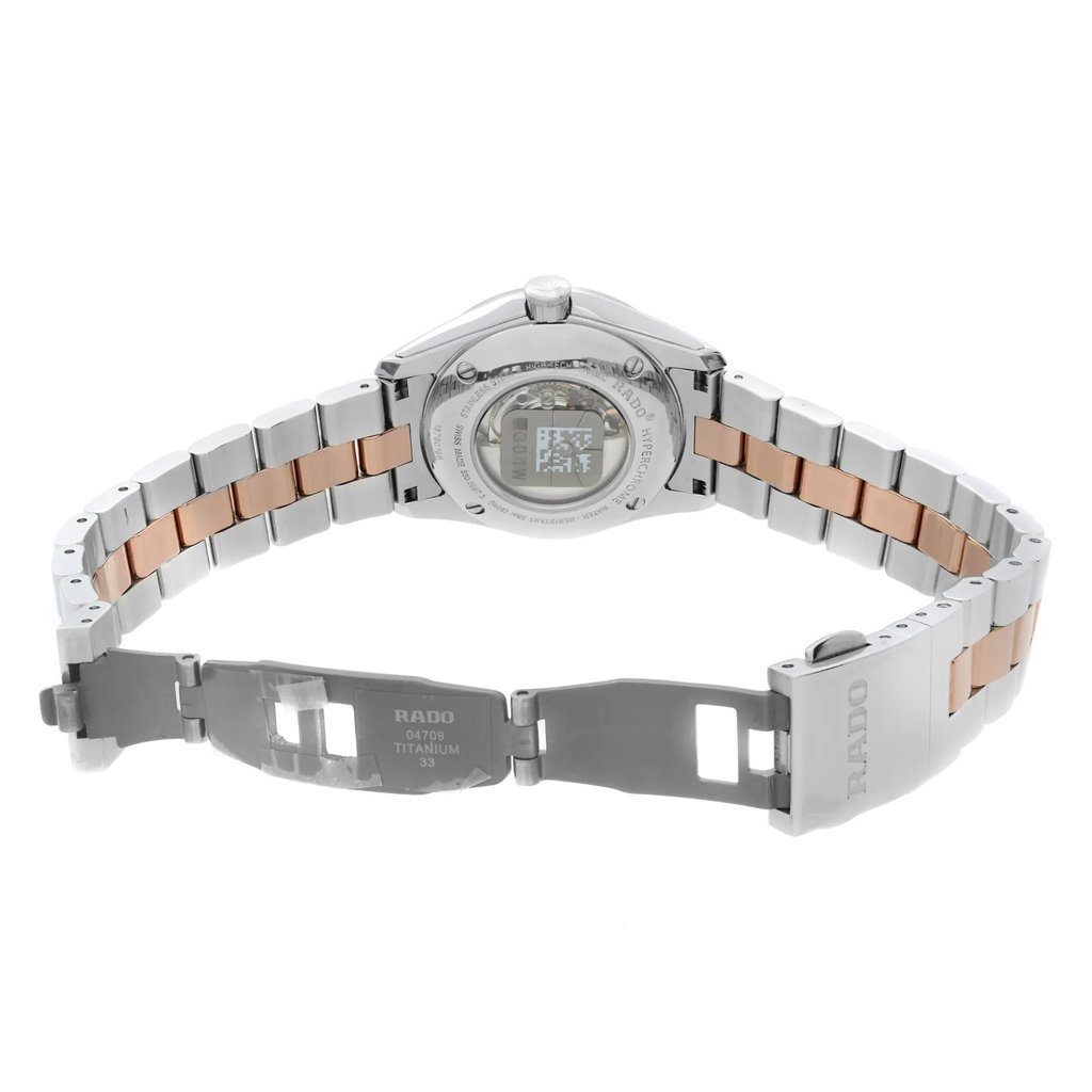 An image of a wristwatch taken from the back view, displaying the open clasp. The watch is positioned horizontally, showing the inside of the band and the case back. The metal bracelet features a two-tone design of silver and rose gold. The angle captures the full length of the watch from a moderate distance, highlighting the clasp and the engraved details on the back. The watch is a display model, evident from its pristine condition.
