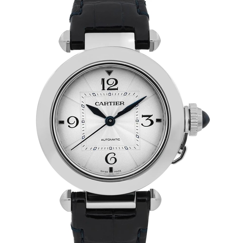 An image of a pre-owned Cartier men's wristwatch. The watch is positioned upright, facing forward, and is captured from a straight-on angle at a close distance. It features a round stainless steel case, a white dial with black numerals at 12, 3, 6, and 9 o'clock, and blue sword-shaped hands. The watch has a black leather strap and a distinct crown on the right side.