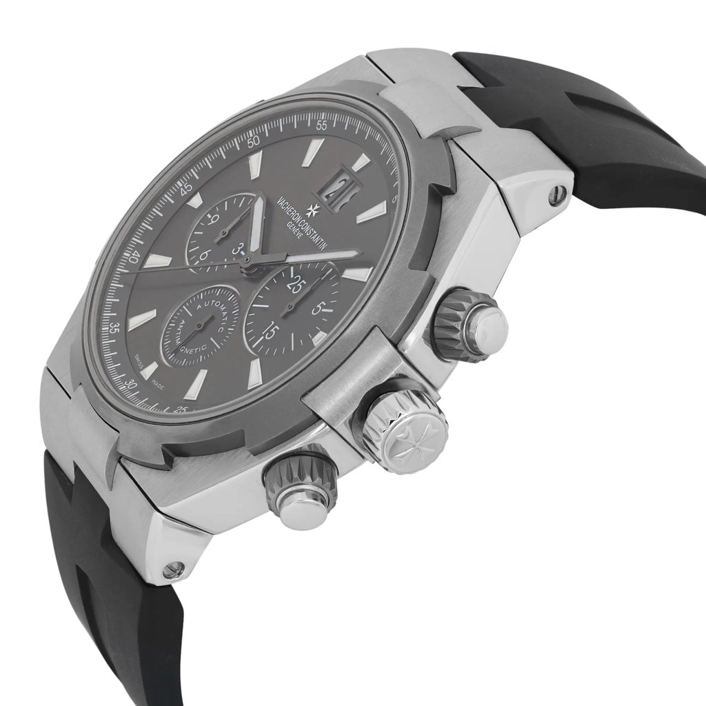 An image of a pre-owned Vacheron Constantin men's wristwatch captured from a low-angle, side perspective. The watch features a stainless steel case, grey dial with luminous hands, and a date indicator. The timepiece is positioned close-up, highlighting its intricate details and the black rubber strap.