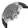 An image of a pre-owned Vacheron Constantin men's wristwatch captured from a low-angle, side perspective. The watch features a stainless steel case, grey dial with luminous hands, and a date indicator. The timepiece is positioned close-up, highlighting its intricate details and the black rubber strap.
