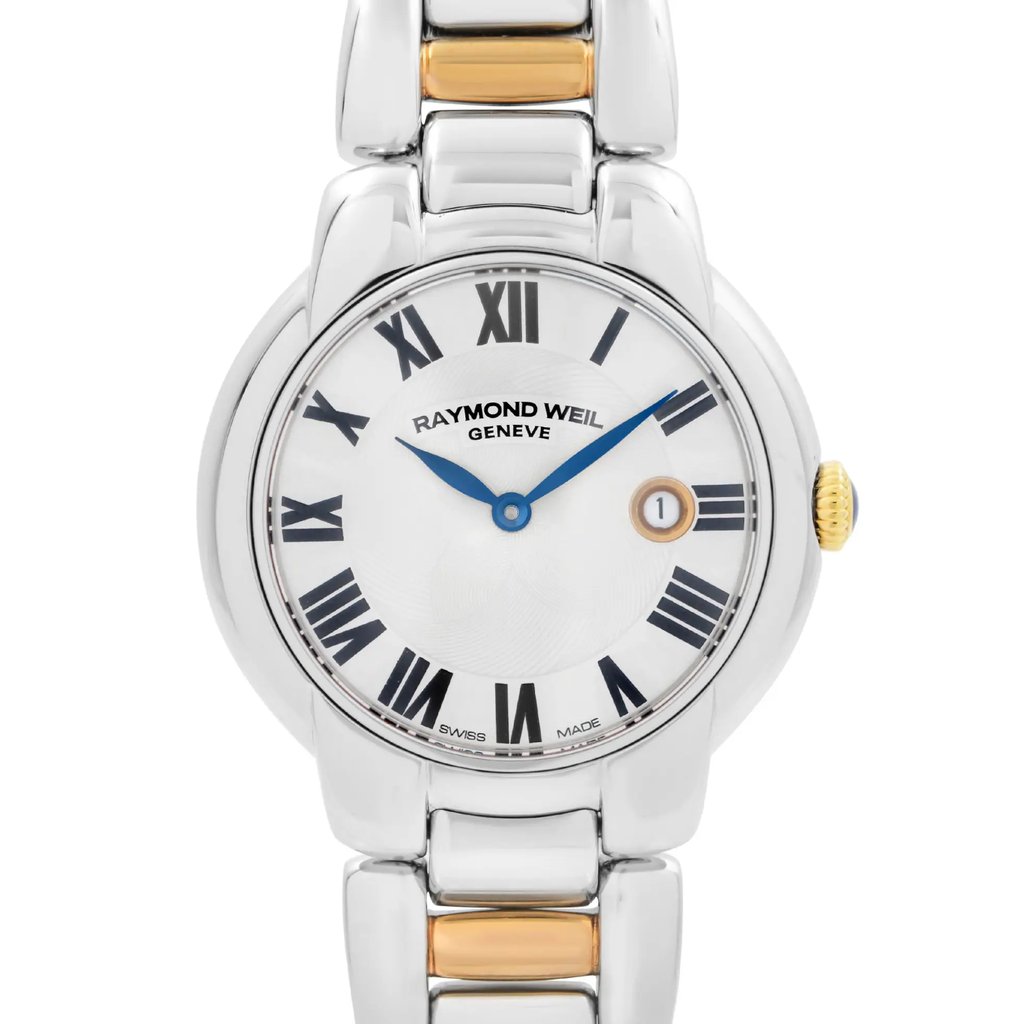 An image of a Raymond Weil luxury women's wristwatch, shown in a front close-up shot focusing on the watch face. The round dial is silver with Roman numeral indices marking a 12-hour layout. The bezel is gray, and the case and band are crafted from stainless steel, with a touch of gold on the crown. The watch features a date indicator and is in excellent, unworn condition.