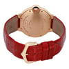 An image of a pre-owned Cartier women's wristwatch viewed from the back at a slight angle, showcasing the gold-toned case and engraved brand details. The watch is positioned slightly to the left, with the focus on the case back and clasp. The red leather strap, featuring a textured pattern, is prominently displayed, with the gold buckle facing the viewer. The watch is photographed at a close distance, highlighting the craftsmanship and design elements.