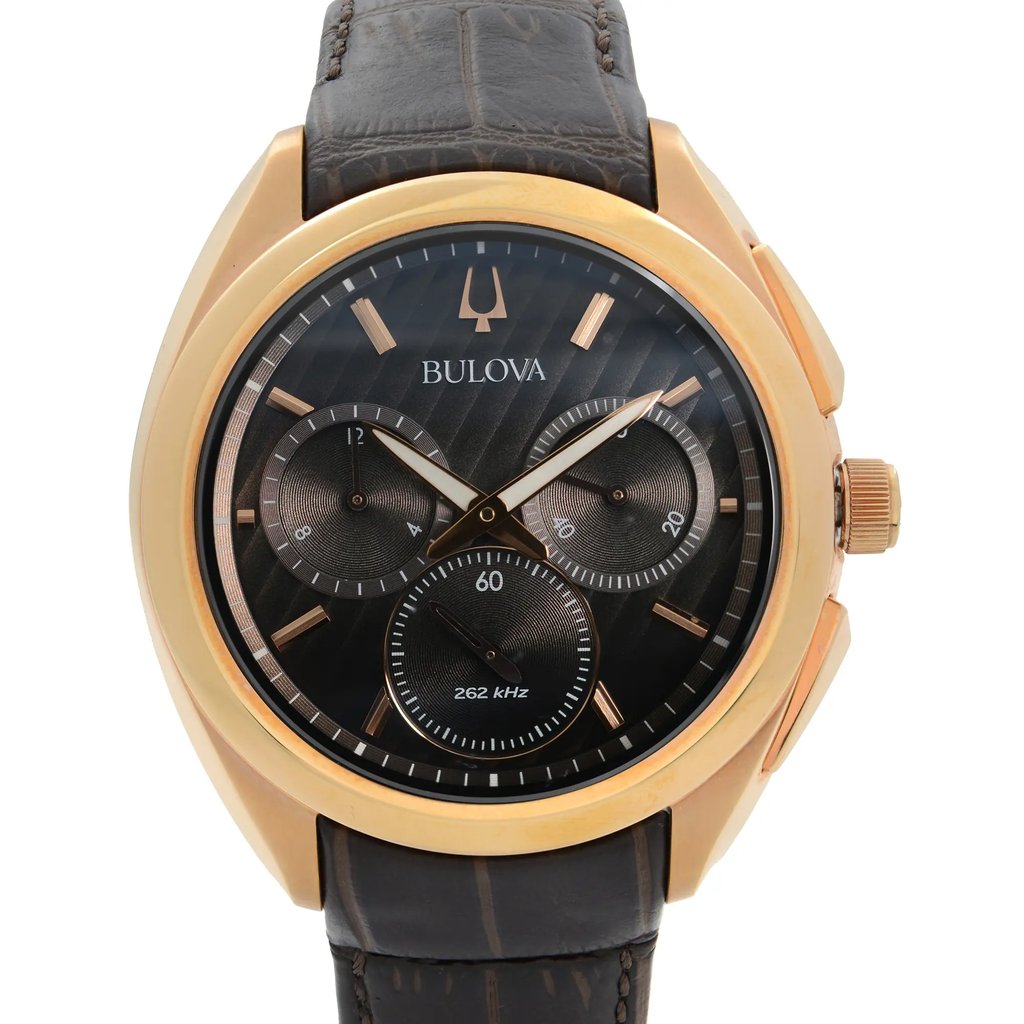 An image of a men's Bulova wristwatch in new condition with defects, presented in a front close-up shot that focuses on the watch face. The watch has a round shape, with a brown dial and rose gold-tone bezel. The band is made of leather, and the case is stainless steel. The watch features a casual style with a 12-hour dial, multiple subdials, and stick indexes. It also includes chronograph functionality, luminous hands, and a small seconds subdial. The image is taken from a direct front angle and the watch fills the frame, providing a detailed view of its features.