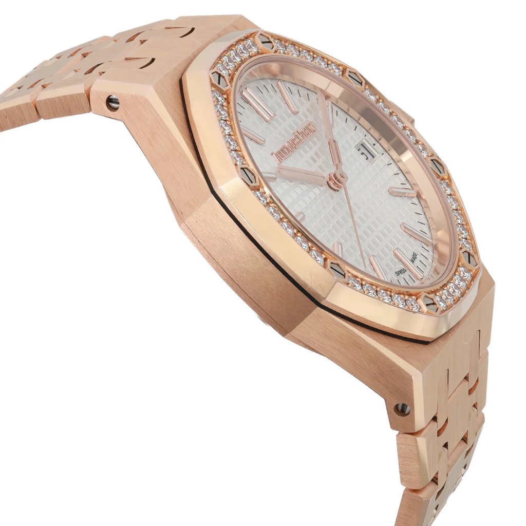 An image of a pre-owned Audemars Piguet men's wristwatch, shown from a side profile view opposite the crown. The watch features a luxurious rose gold case and band, with an octagonal shape. The bezel is also rose gold and adorned with diamonds. The silver dial displays a Tapisserie pattern, and the watch has luminous hands. The overall condition is classified as good.