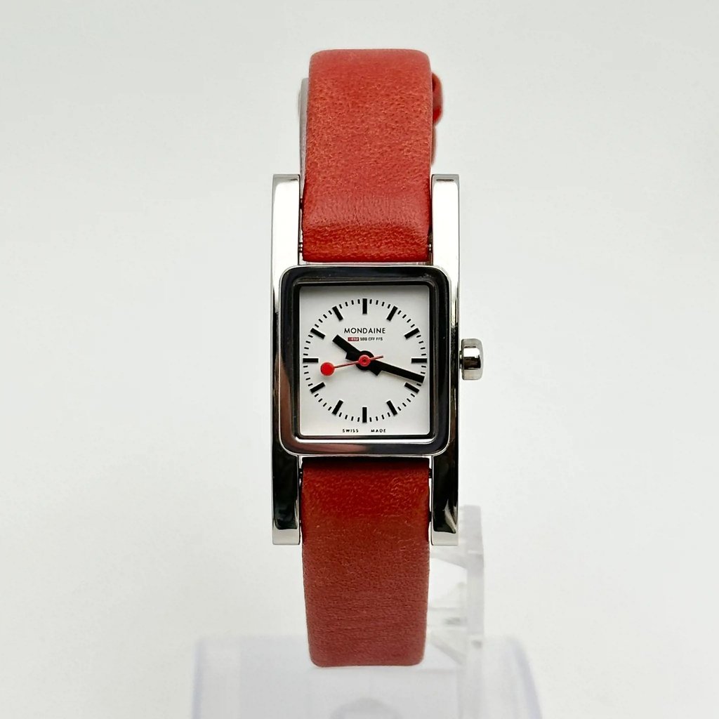An image of a Wristwatch by mondaine. This Pre Owned item is designed for Women, featuring a Casual style. It has a Quartz movement and an Analog display with a White dial color. The indices include 12-Hour Dial. The band is made of Leather and the case is made of Stainless Steel. The watch has a Square shape with a case size of 20 mm and a case thickness of 6 mm.