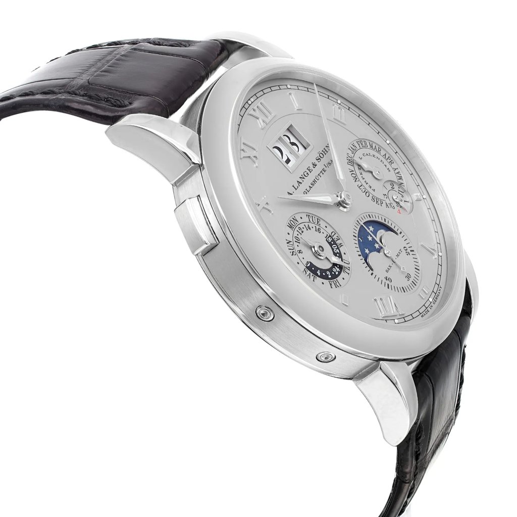 An image of a pre-owned wristwatch captured from a side profile view, opposite the crown. The watch features a polished metal case, a detailed dial with multiple subdials, and a leather strap. The angle highlights the sleek design and intricate details of the watch face, providing a close-up perspective.
