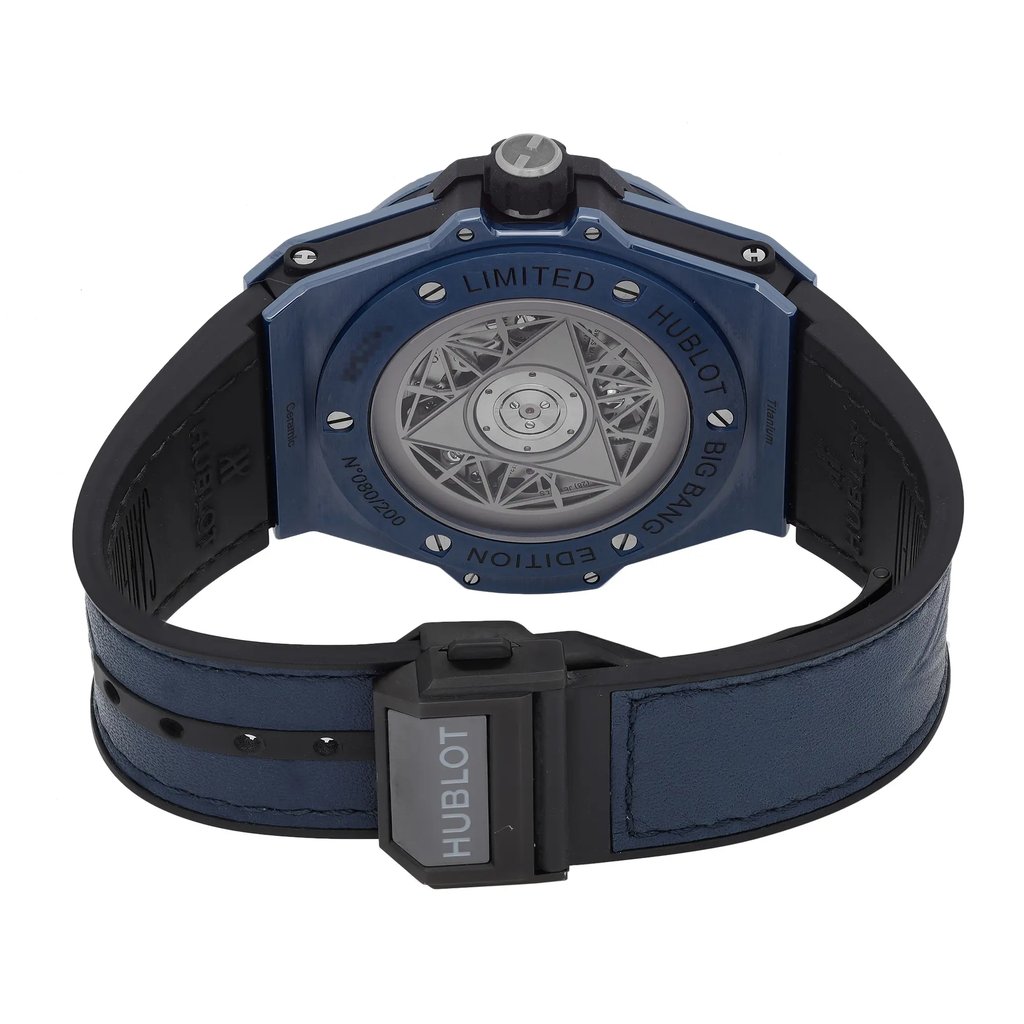 An image of a pre-owned wristwatch viewed from the back, showcasing the intricate mechanism through a transparent caseback. The watch is positioned to display the clasp closely, with branding visible. The angle highlights the circular design and limited edition markings on the blue case, complemented by a black and blue strap.
