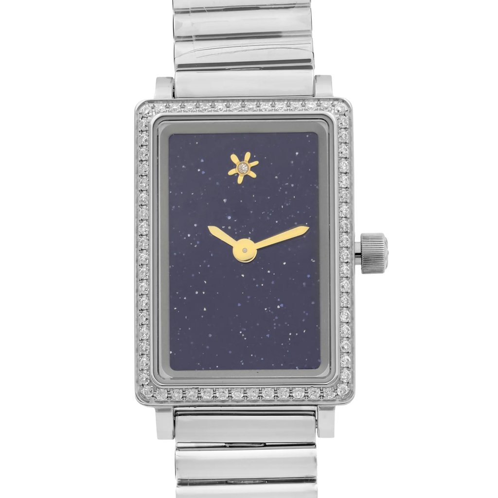 An image of an unworn wristwatch, featuring a front close-up shot of the watch face. The rectangular dial is dark blue with a starry pattern, gold hands, and a small sun emblem. The watch case is adorned with a border of small, sparkling stones. The metallic strap is partially visible, showing its polished links.