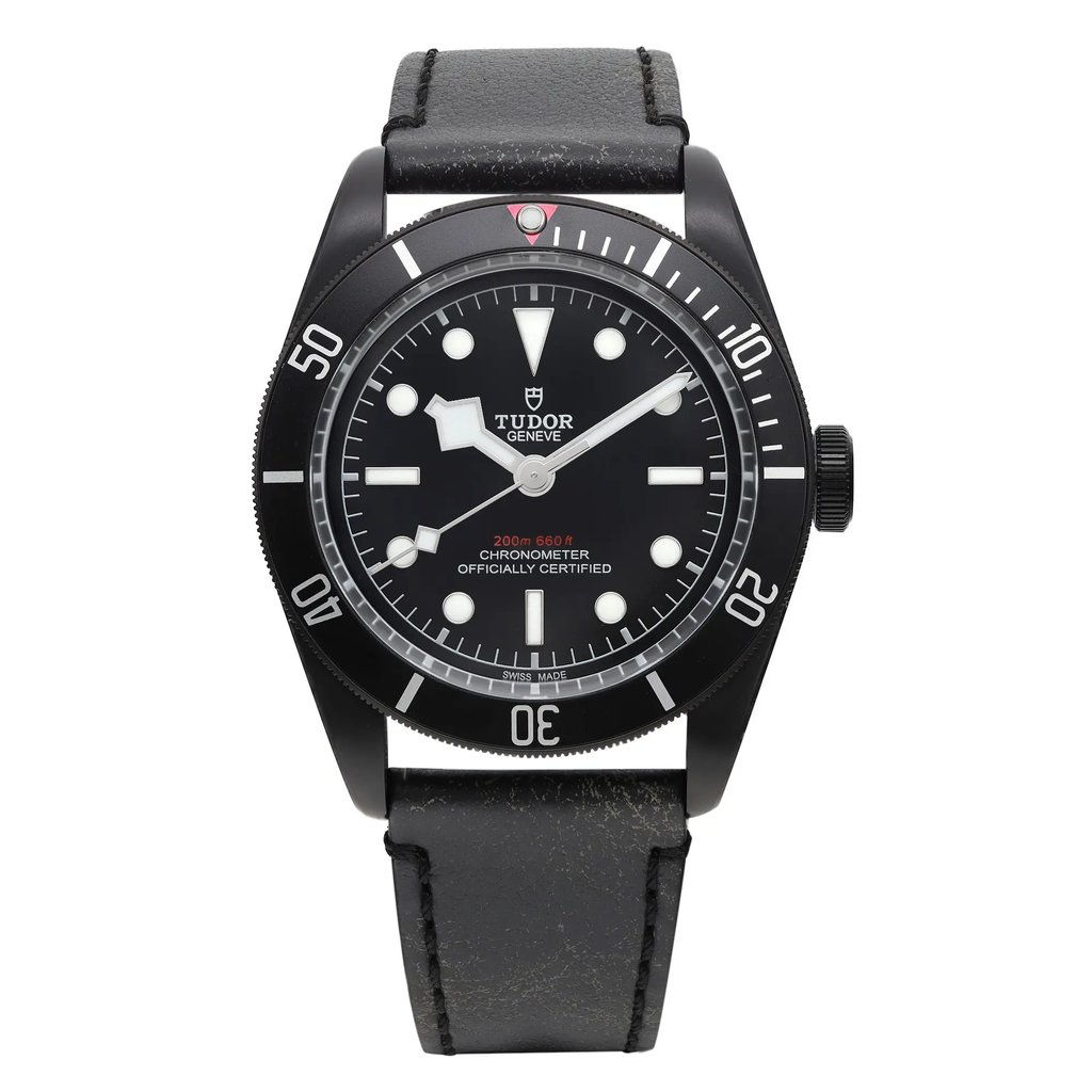 An image of a wristwatch taken from a front full-frontal view. The watch face is centered in the frame, showcasing its circular black dial with white hour markers and hands. The bezel displays numerals at intervals. The watch is in display model condition, with a black leather strap visible at the top and bottom. The angle is straight-on, providing a direct and clear view of the watch's features.